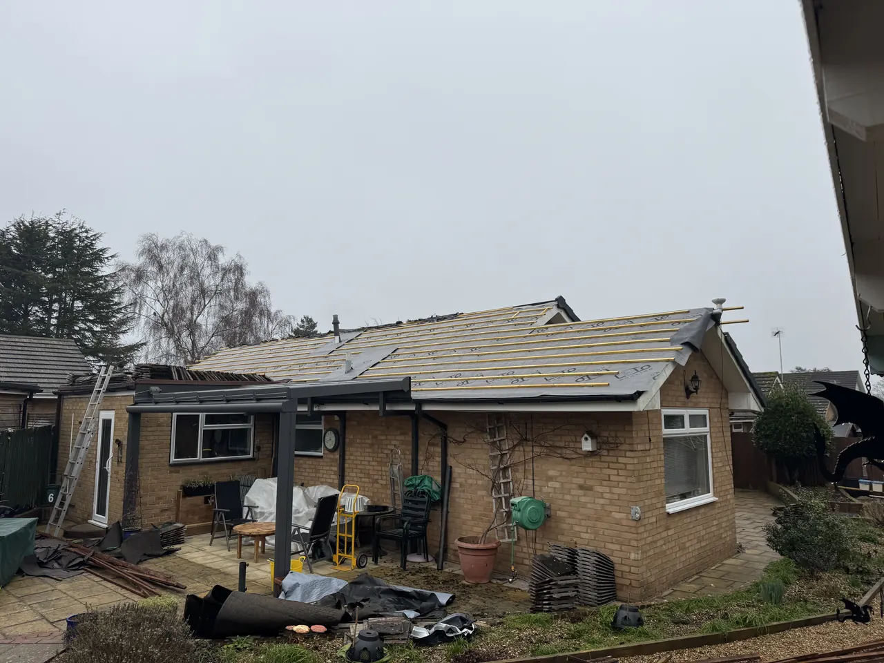 Bungalow roof stripped with membrane and battens on, scaffold around it