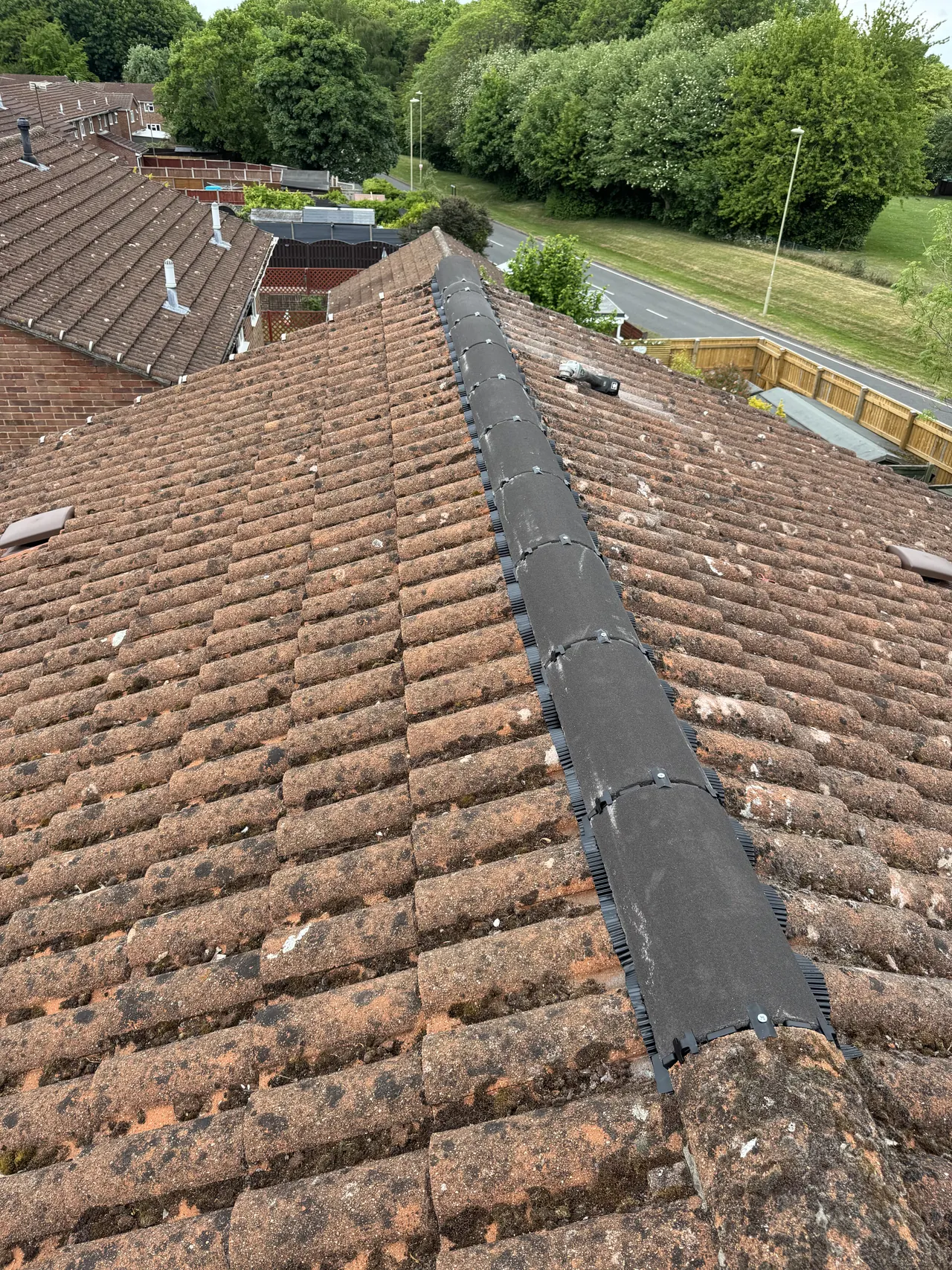 New dry-fix ridge along the top of an existing concrete tiled roof